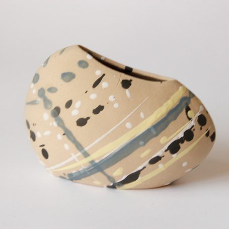 Abstract ceramic vase with earthy tones and painted patterns of blue and yellow.