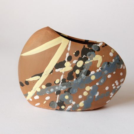 Abstract pottery piece with a smooth, irregular shape and multi-coloured paint splashes.