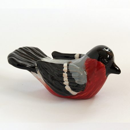 Ceramic figurine of a bird in black, grey, and red colours.