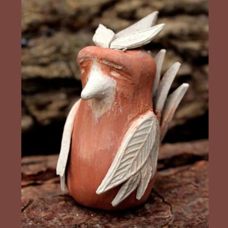 Terracotta bird figurine with white decorative feathers and a serene expression.