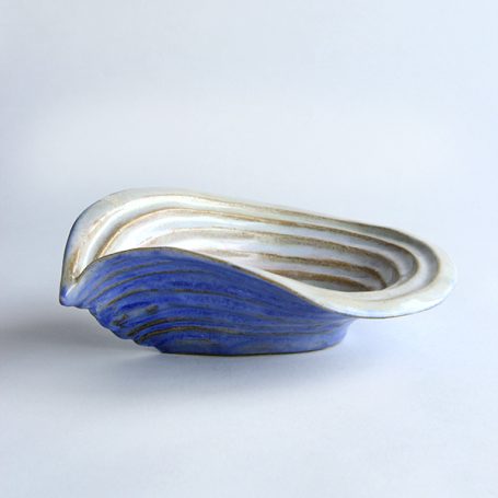 Ceramic bowl shaped like a seashell, featuring blue and white striations.