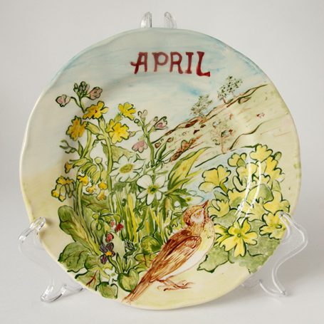 Decorative plate featuring flowers and a bird, labelled "APRIL."