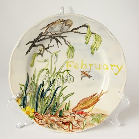 Decorative plate featuring birds, greenery, and the word "February."