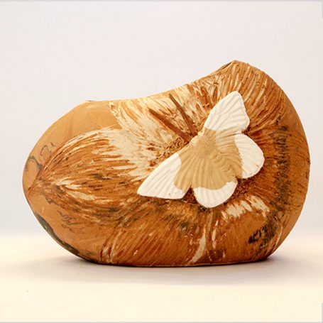Relief sculpture of a stylised butterfly on a smooth, natural ceramic base.