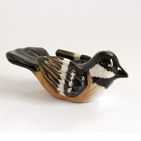 Ceramic bird figurine in shades of black, brown, and white, with a glossy finish.