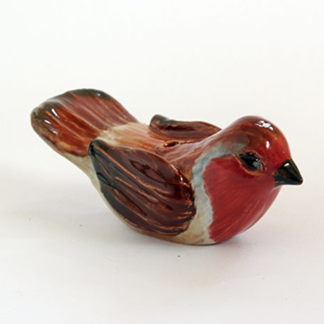 Ceramic bird figurine in red and brown tones, detailed features.