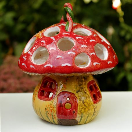 A colourful mushroom-shaped ornament with a door and windows.