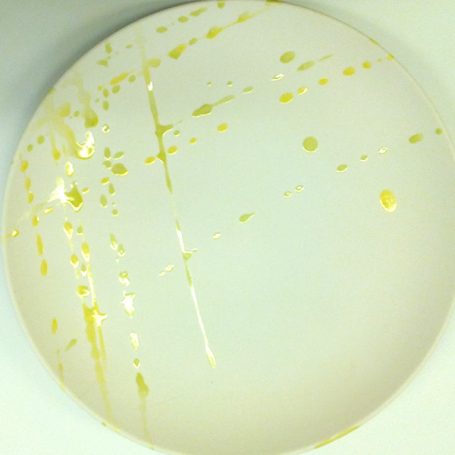 White surface with yellow splashes and streaks.