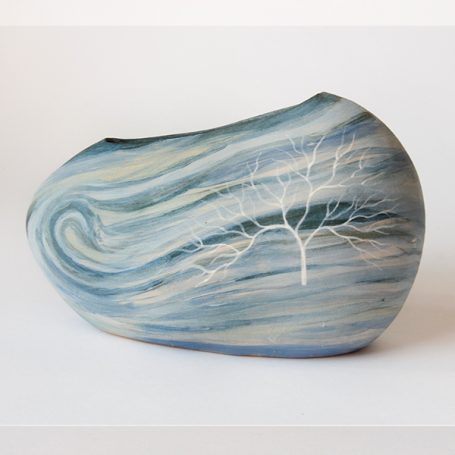 Ceramic vase with swirling blue patterns and a white tree design.