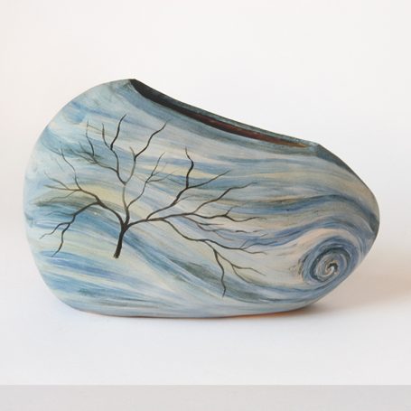 Ceramic vase with a swirl pattern and a painted tree branch design.