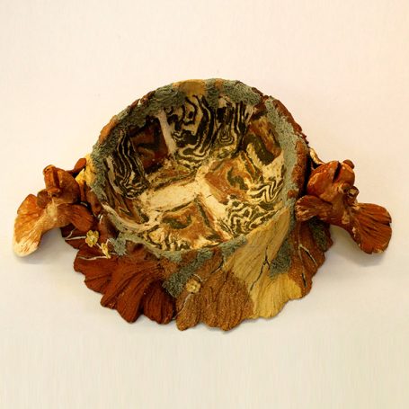 A decorative bowl featuring intricate carvings and natural textures.