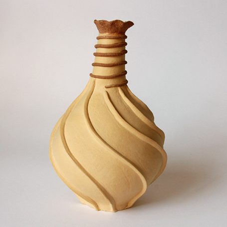 Curved ceramic vase with a patterned spiral design and a flared top.