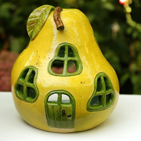 A yellow pear-shaped house with green windows and a door.
