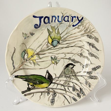 Ceramic plate decorated with birds and branches, labelled "January."