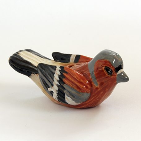 Ceramic figurine of a bird with brown, grey, and black detailing.